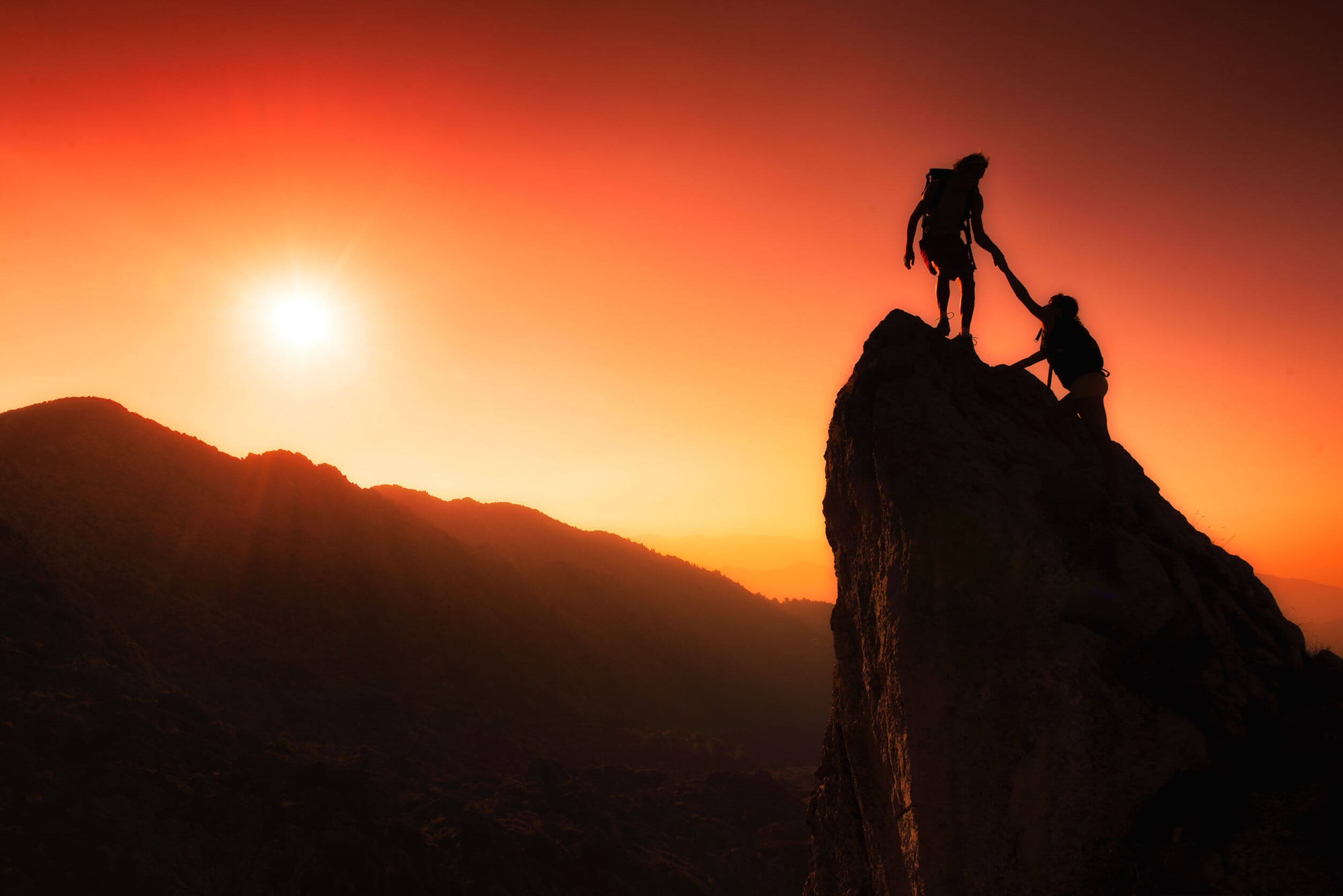 Two people climbing a rock